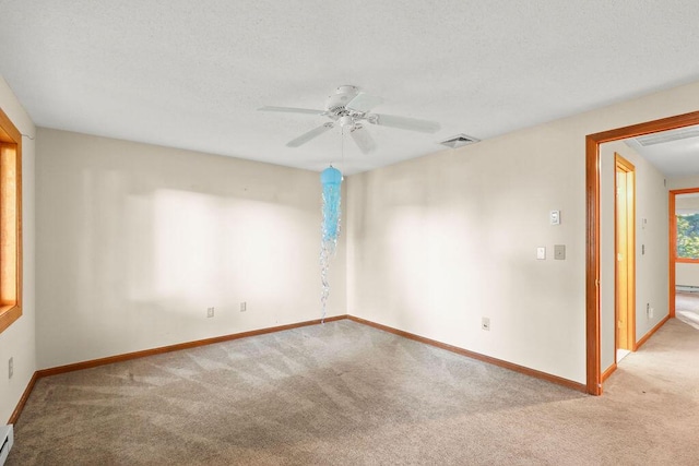 carpeted empty room with ceiling fan and a baseboard heating unit