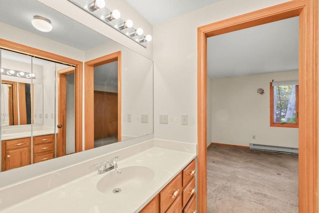 bathroom featuring baseboard heating and vanity