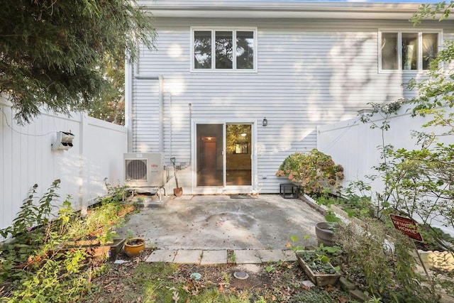 back of property with ac unit and a patio