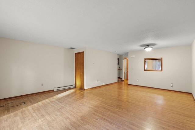 empty room with light hardwood / wood-style floors and baseboard heating