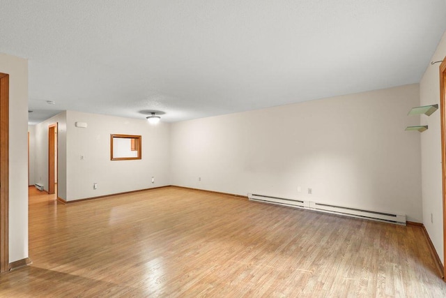 unfurnished room with light wood-type flooring and baseboard heating