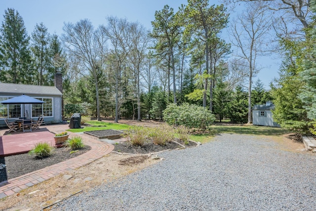 view of yard with an outbuilding, a storage shed, a wooden deck, and a gazebo