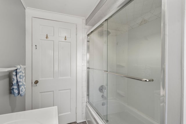 bathroom with bath / shower combo with glass door and ornamental molding