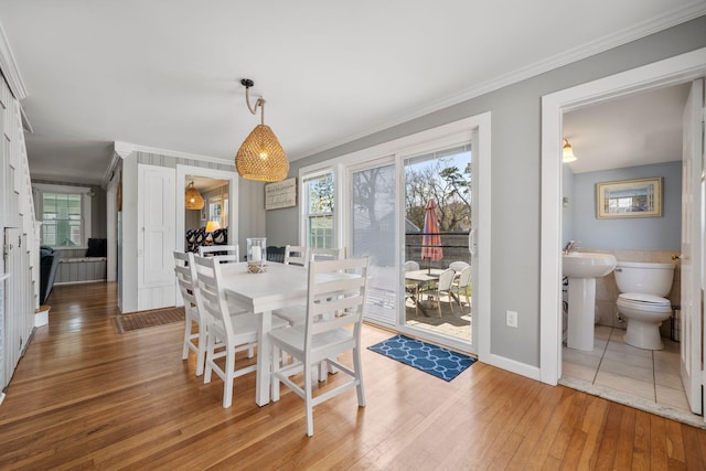 dining room featuring ornamental molding, hardwood / wood-style flooring, plenty of natural light, and baseboards