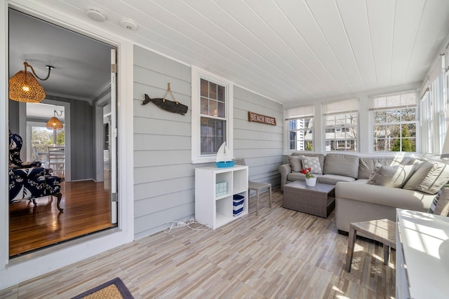 sunroom / solarium with wood finished floors and ornamental molding