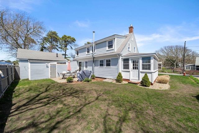 rear view of property featuring an outdoor structure, a chimney, and entry steps
