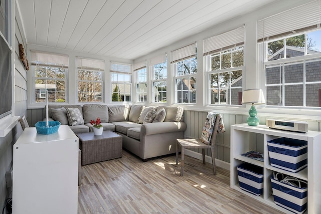 sunroom / solarium featuring healthy amount of natural light, wooden ceiling, wood finished floors, and a deck