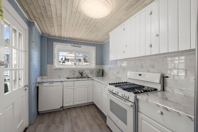 kitchen with white appliances, a sink, wood ceiling, tasteful backsplash, and white cabinets
