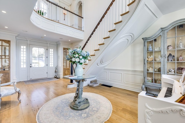 foyer entrance featuring ornamental molding and light hardwood / wood-style flooring