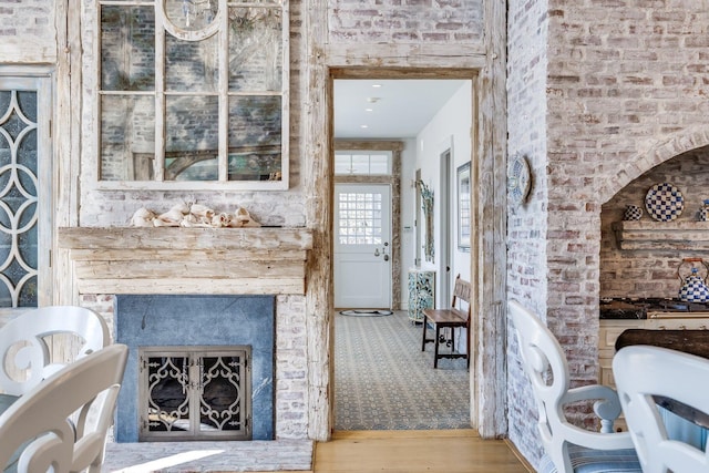 interior space with wood-type flooring and a brick fireplace