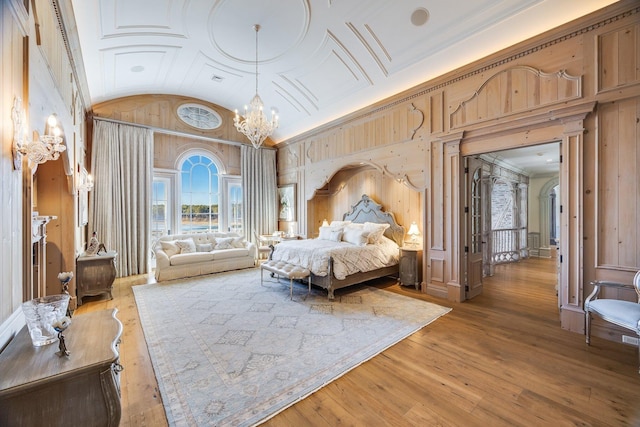 bedroom with lofted ceiling, a notable chandelier, and light hardwood / wood-style flooring