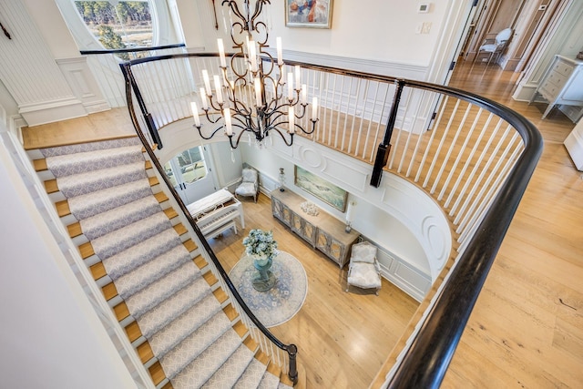 staircase featuring hardwood / wood-style flooring and a notable chandelier