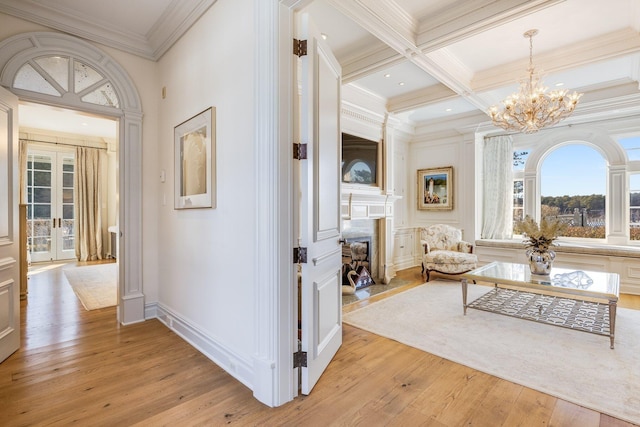 corridor featuring crown molding, an inviting chandelier, beam ceiling, coffered ceiling, and light hardwood / wood-style floors