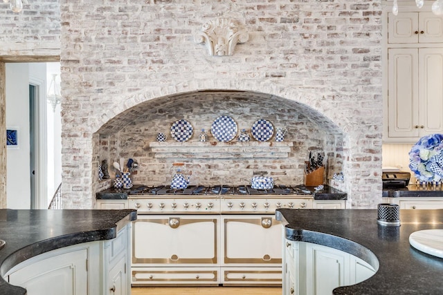 kitchen with double oven range and brick wall