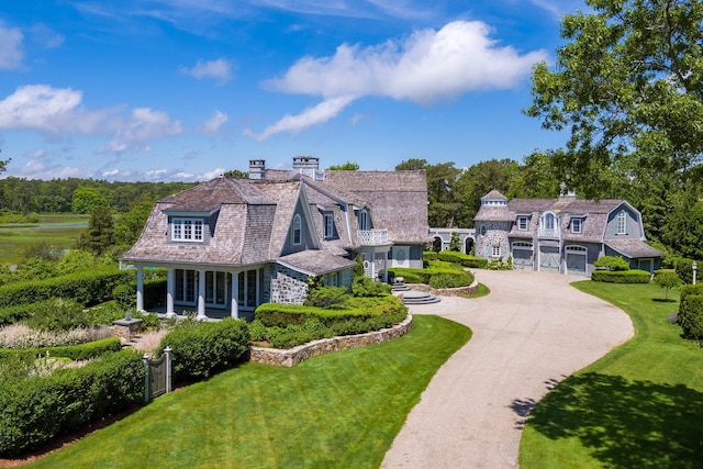 view of front of house with a garage, a porch, and a front lawn