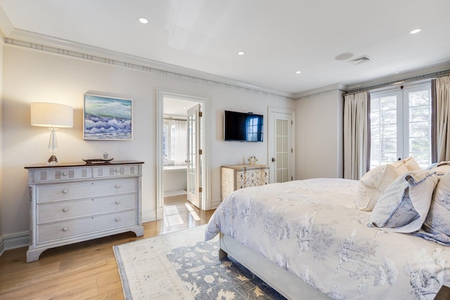 bedroom with multiple windows, ornamental molding, light hardwood / wood-style floors, and ensuite bathroom