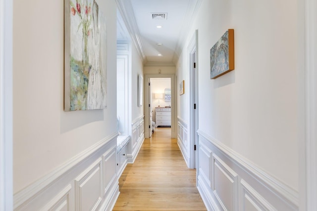 hallway with crown molding and light hardwood / wood-style flooring