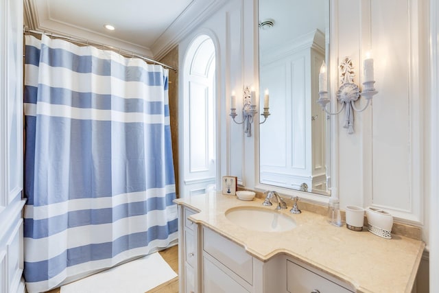 bathroom featuring hardwood / wood-style flooring, crown molding, and vanity