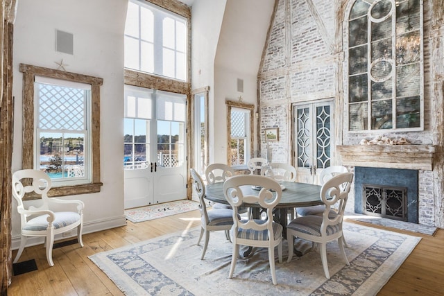 dining area with wood-type flooring, high vaulted ceiling, and french doors