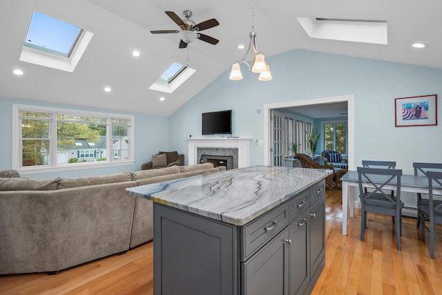 359 Lake Elizabeth Dr, Centerville, MA 02632 - kitchen featuring a skylight, gray cabinets, open floor plan, lofted ceiling, and a fireplace