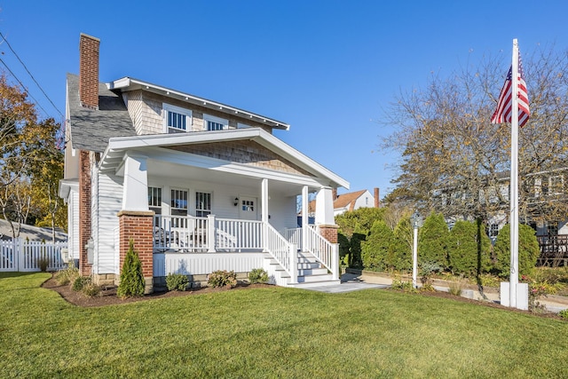 view of front of property featuring a chimney, a porch, a front yard, and fence