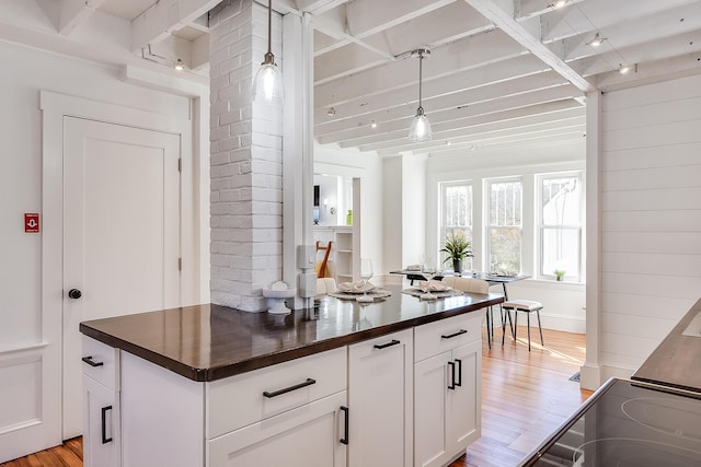 kitchen featuring hanging light fixtures, butcher block countertops, light wood-style flooring, and white cabinetry