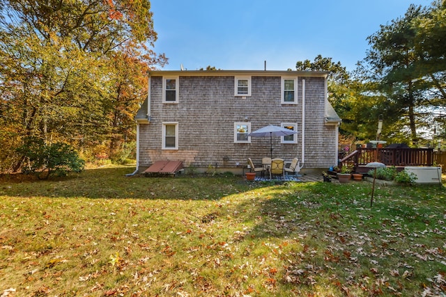 rear view of property featuring a lawn and a deck