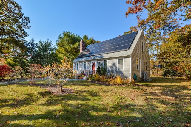 exterior space with roof mounted solar panels, a chimney, and a yard