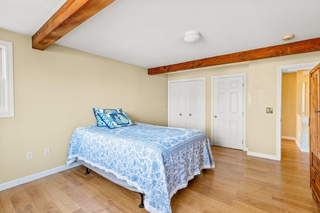 bedroom featuring hardwood / wood-style flooring and beamed ceiling