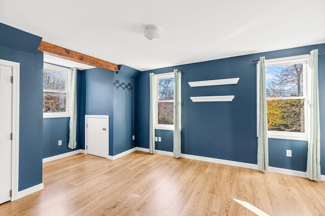 empty room featuring hardwood / wood-style floors and beamed ceiling