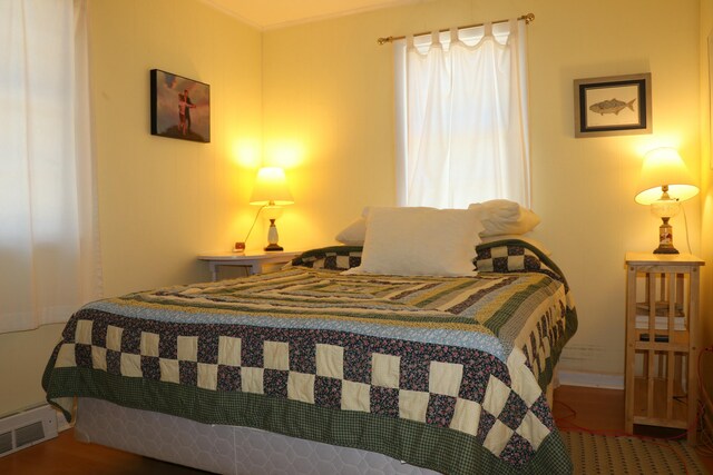 bedroom featuring wood finished floors and visible vents