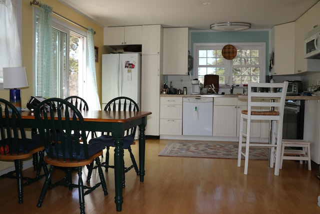 kitchen with white cabinetry, a toaster, white appliances, and light wood-style flooring