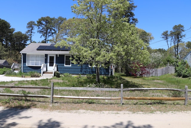 25 Day Rd, Wellfleet, MA 02667 - view of front of property with roof mounted solar panels and a fenced front yard