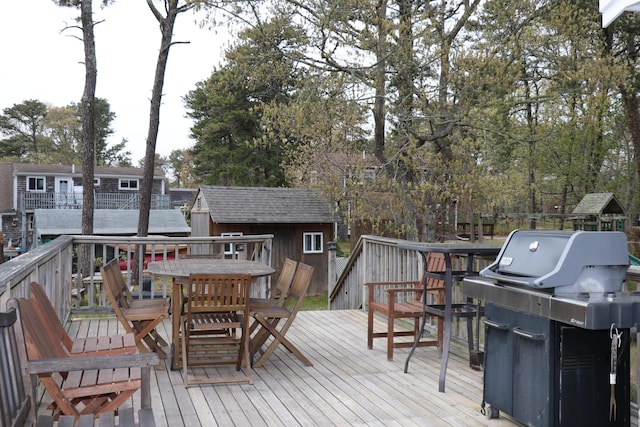 25 Day Rd, Wellfleet, MA 02667 - deck with outdoor dining space, area for grilling, a shed, and an outbuilding