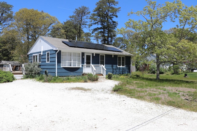 25 Day Rd, Wellfleet, MA 02667 - view of front of home with roof mounted solar panels and a porch
