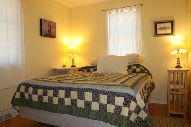 bedroom featuring wood finished floors and visible vents