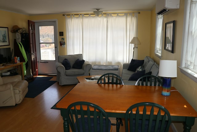 dining area with wood finished floors and a wall unit AC