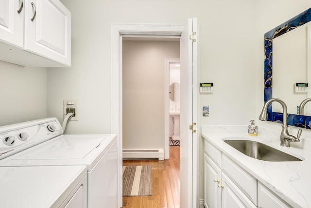 335 Falmouth Woods Rd, East Falmouth, MA 02536 - laundry area with a baseboard heating unit, cabinet space, washing machine and dryer, and light wood-style flooring