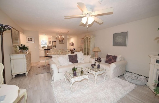 24 Highland Ter Unit 2404, White Horse Beach, MA 02360 - living room featuring ceiling fan with notable chandelier, baseboard heating, a high end fireplace, and light wood-type flooring