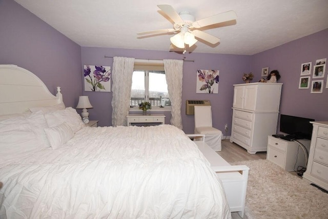 bedroom featuring light wood-type flooring, ceiling fan, and a wall mounted AC