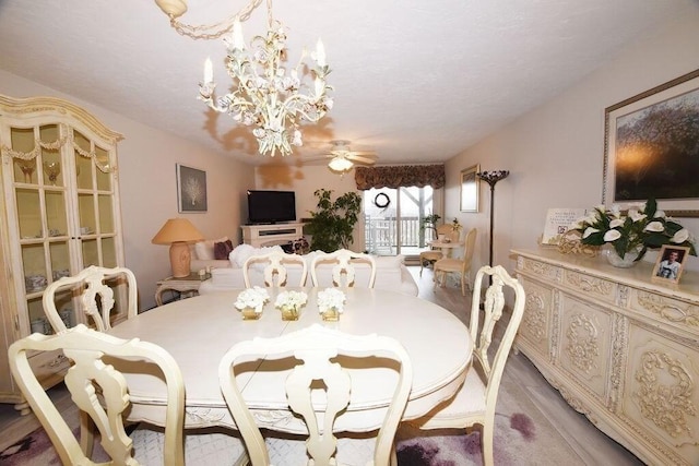 dining area featuring ceiling fan with notable chandelier