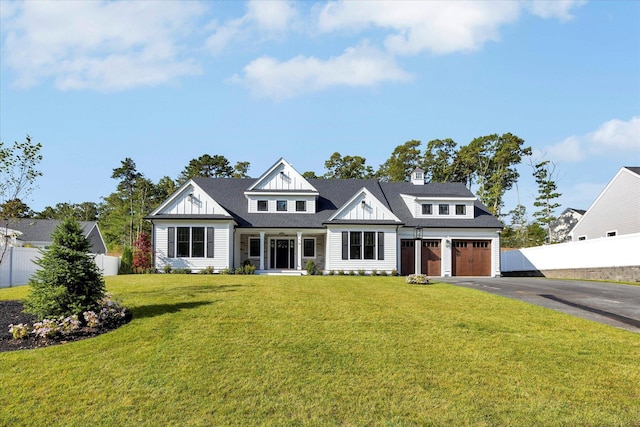 view of front of property featuring aphalt driveway, a front yard, fence, and an attached garage