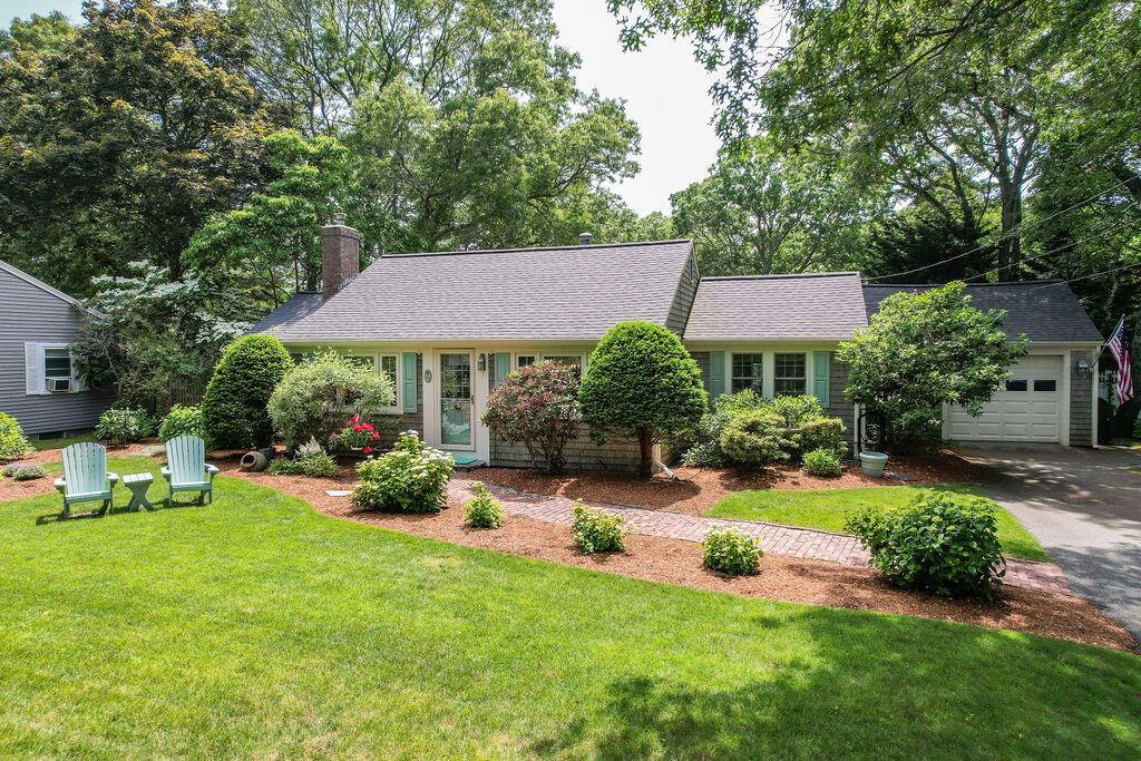 105 Pond St, South Yarmouth, MA 02664 - view of front of house featuring a chimney, a front lawn, driveway, a garage, and roof with shingles