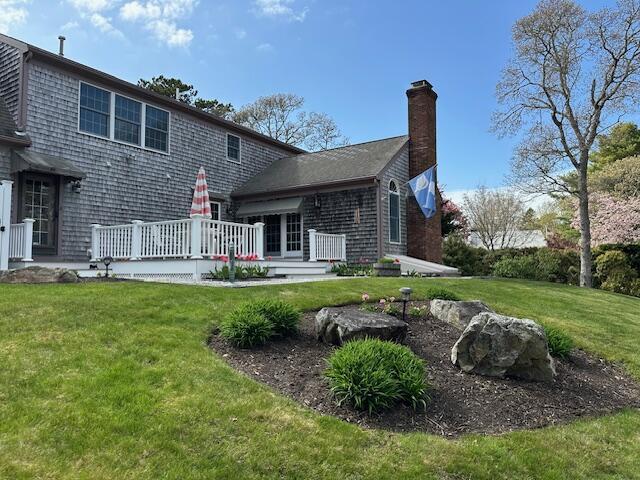 30 Monomessat Way, Chatham, MA 02633 - rear view of property featuring a chimney, a deck, and a lawn