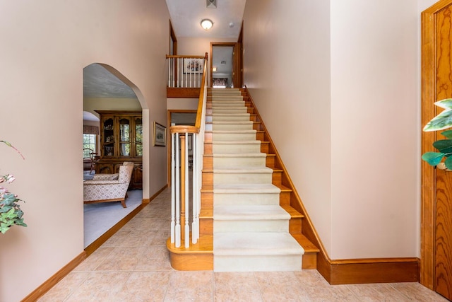 30 Monomessat Way, Chatham, MA 02633 - staircase featuring arched walkways, tile patterned floors, baseboards, and a high ceiling