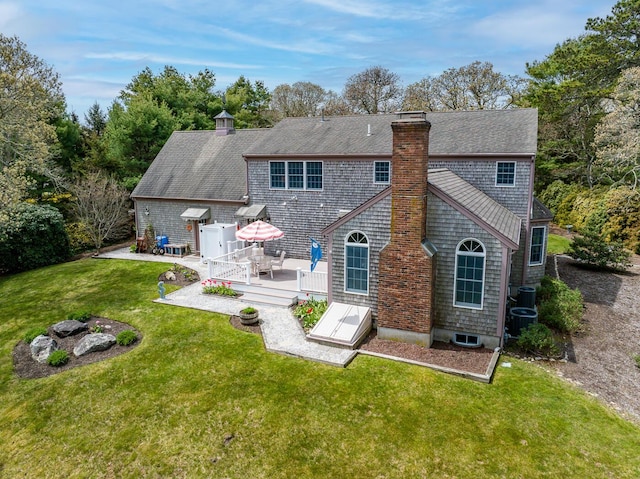 30 Monomessat Way, Chatham, MA 02633 - back of house featuring a chimney, a wooden deck, a lawn, roof with shingles, and cooling unit
