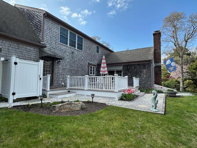 30 Monomessat Way, Chatham, MA 02633 - rear view of property featuring a yard, a chimney, and a wooden deck