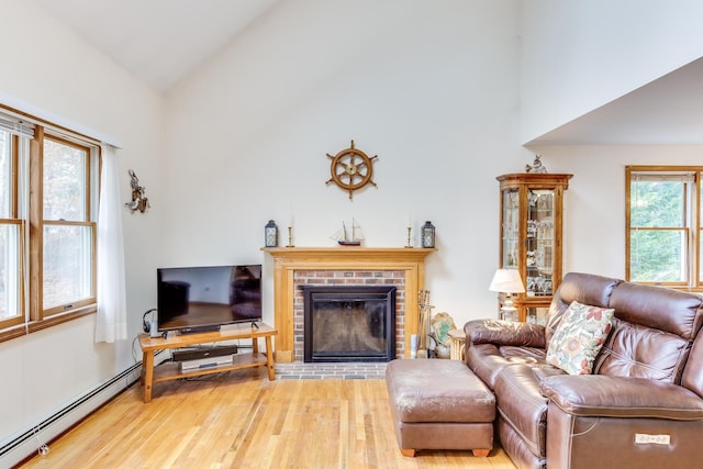 79 Pinewood Cir, Wellfleet, MA 02667 - living room featuring high vaulted ceiling, wood finished floors, a brick fireplace, and a baseboard radiator