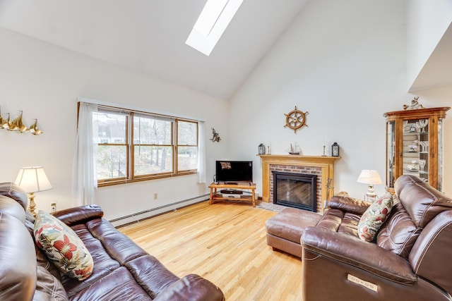 79 Pinewood Cir, Wellfleet, MA 02667 - living room with high vaulted ceiling, wood finished floors, a skylight, a brick fireplace, and baseboard heating