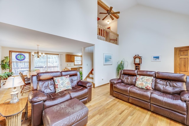 79 Pinewood Cir, Wellfleet, MA 02667 - living room with light wood-style flooring, high vaulted ceiling, ceiling fan with notable chandelier, and stairway